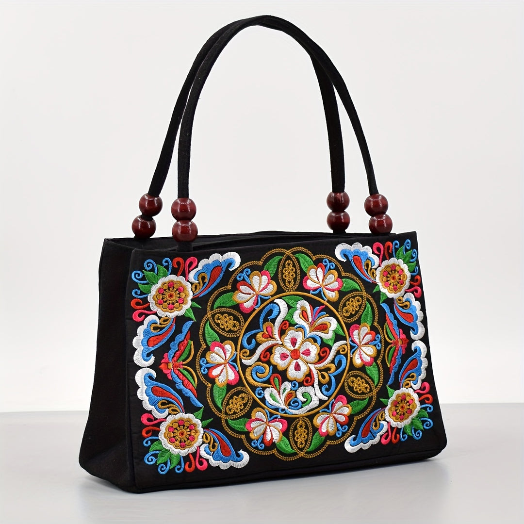 Black handbag with colorful floral embroidery on a white background