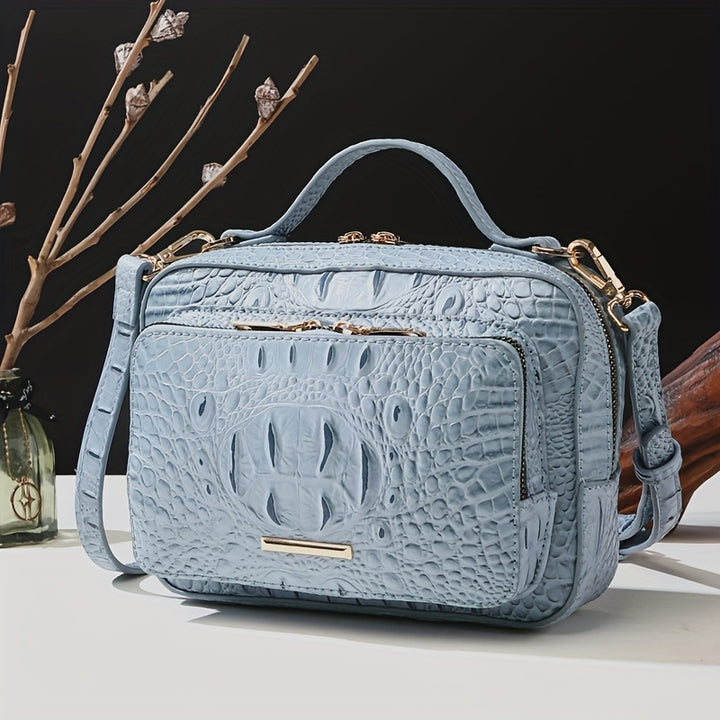 Blue textured handbag with gold accents on a neutral background