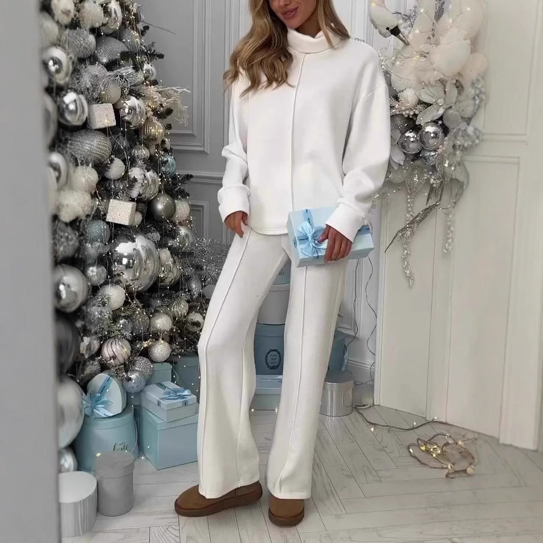 Woman in white outfit standing in a room with decorative Christmas tree and presents.