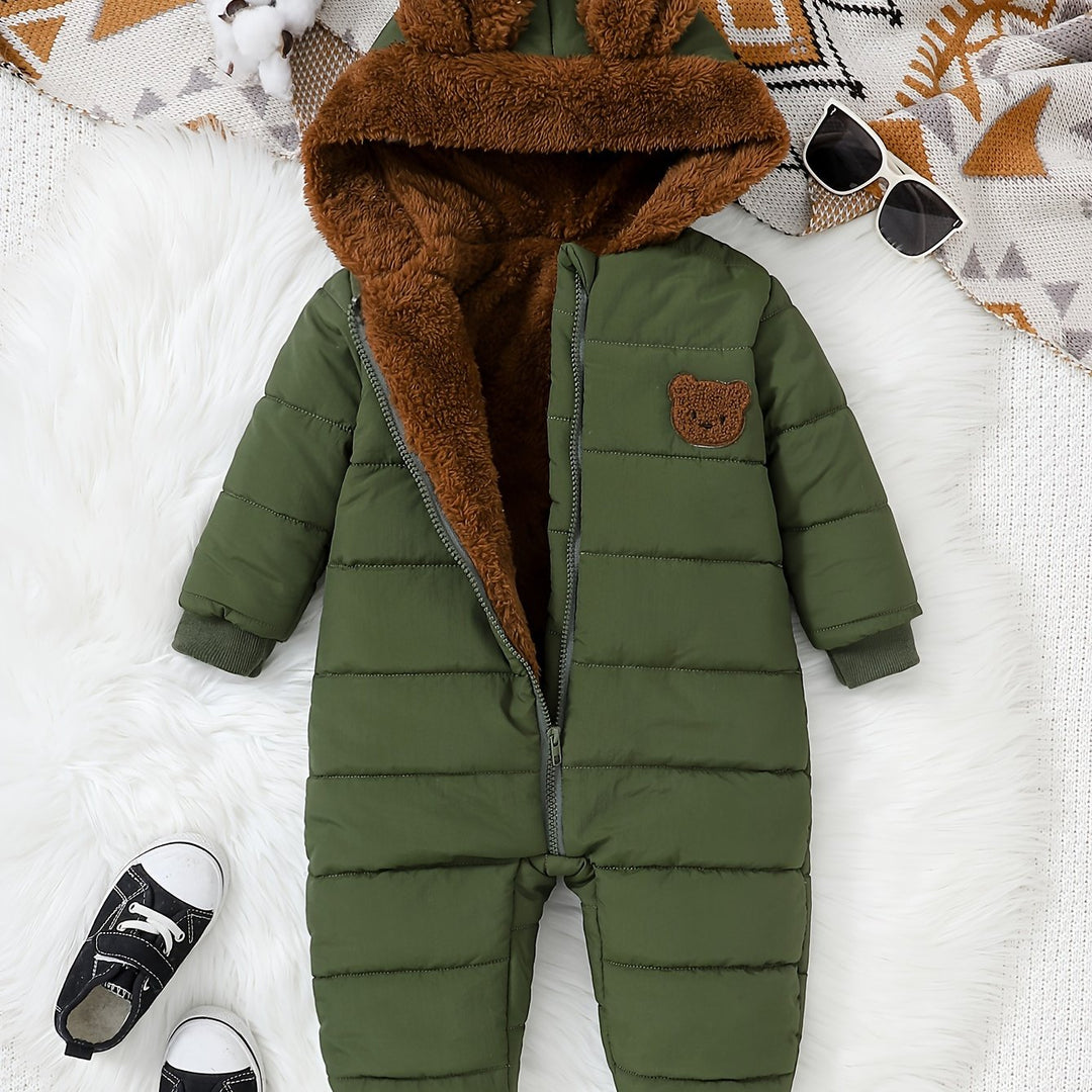 Green baby snowsuit with brown fur hood on a white surface
