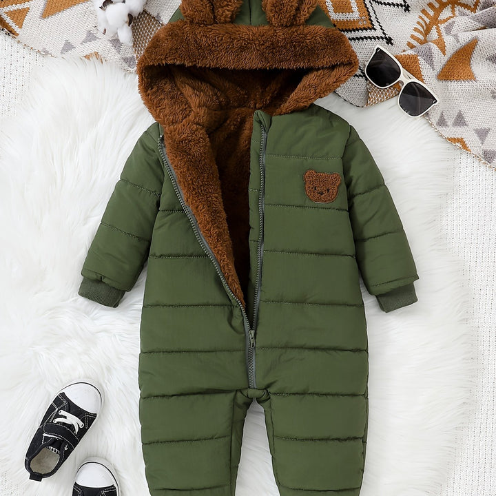 Green baby snowsuit with brown fur hood on a white surface