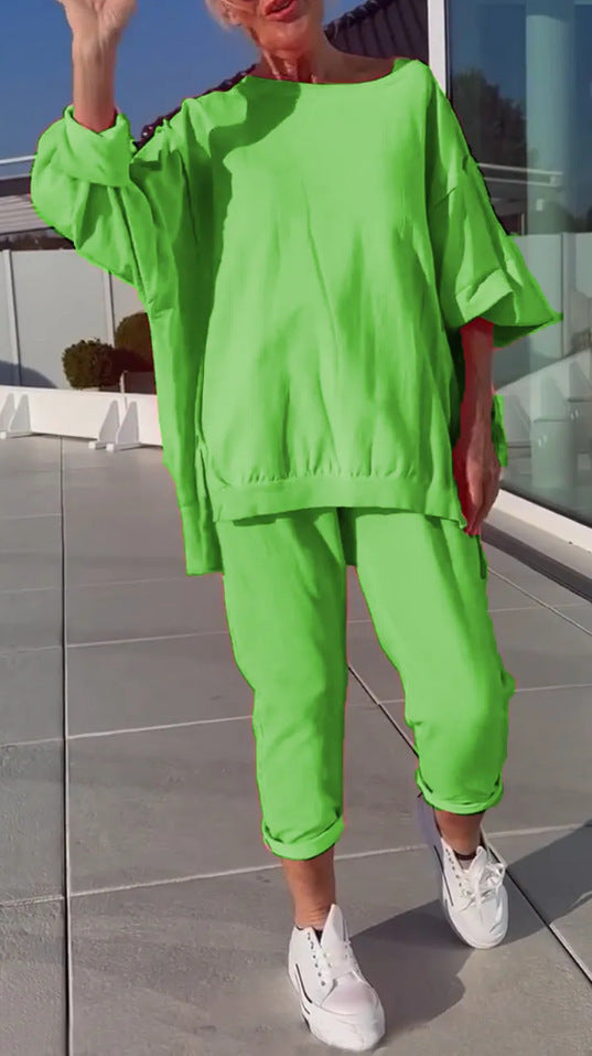 Person wearing a bright green outfit with white sneakers on a reflective surface.