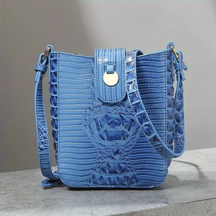 Blue textured handbag on a gray surface with a neutral background