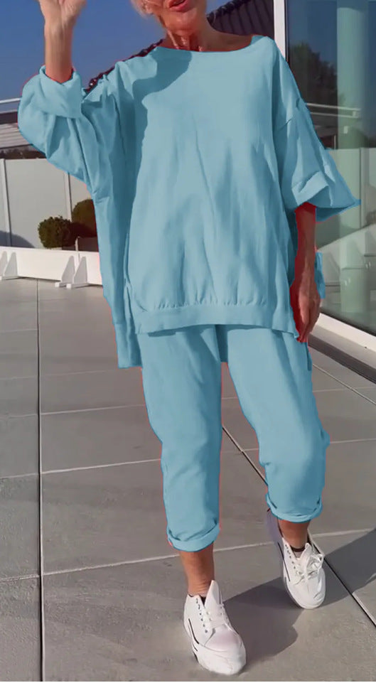 Person wearing a light blue outfit with white sneakers on a reflective surface.