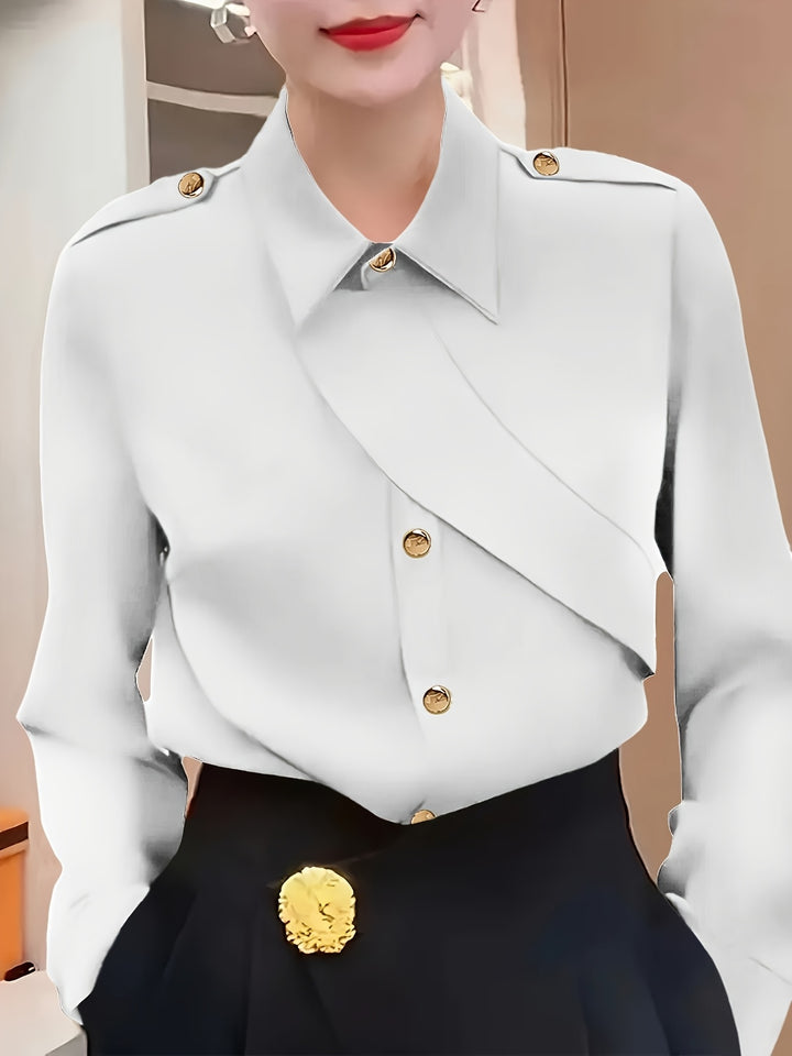 White blouse with gold buttons and black pants worn by a person.