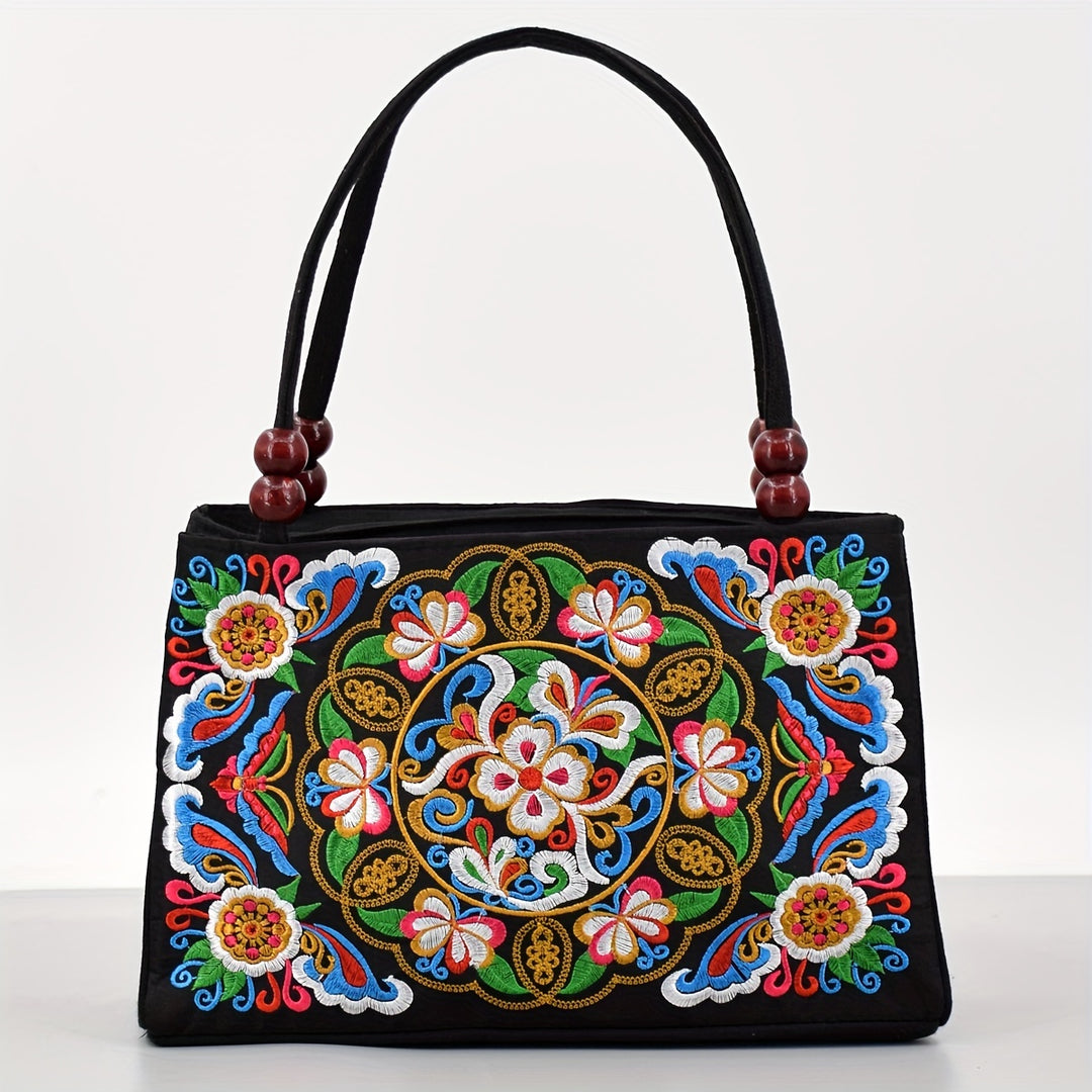 Black handbag with colorful floral embroidery on a white background