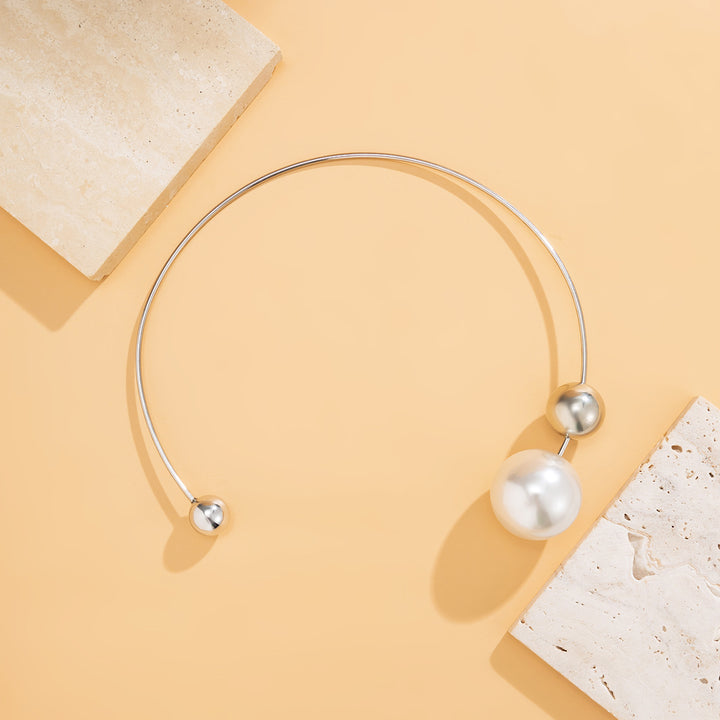 Silver necklace with pearls on a beige background