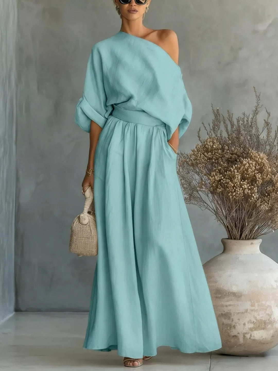 Teal one-shoulder top and wide-leg pants set with draped sleeves and gathered waist