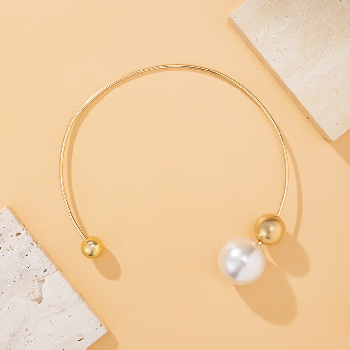 Gold necklace with pearls on a beige background