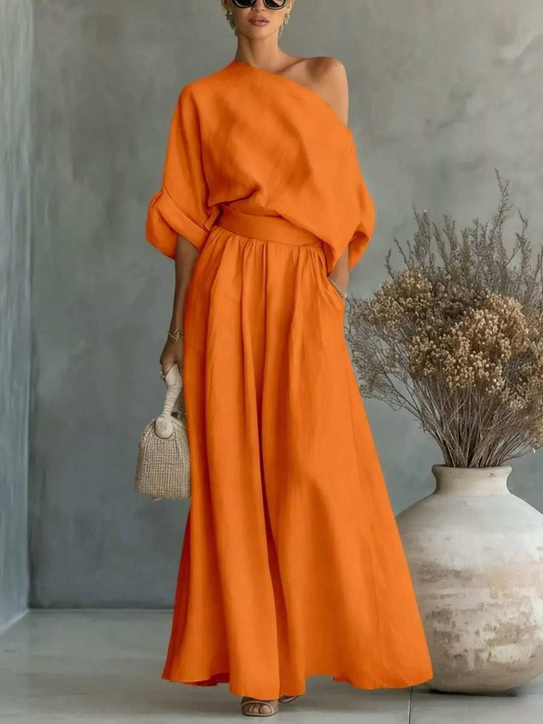 Orange one-shoulder top and wide-leg pants set, draped sleeves and gathered waist