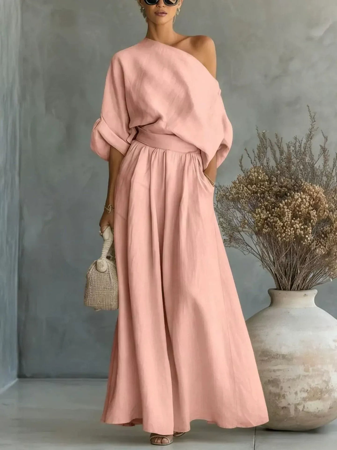 Pink one-shoulder top and wide-leg pants set with draped sleeves and gathered waist