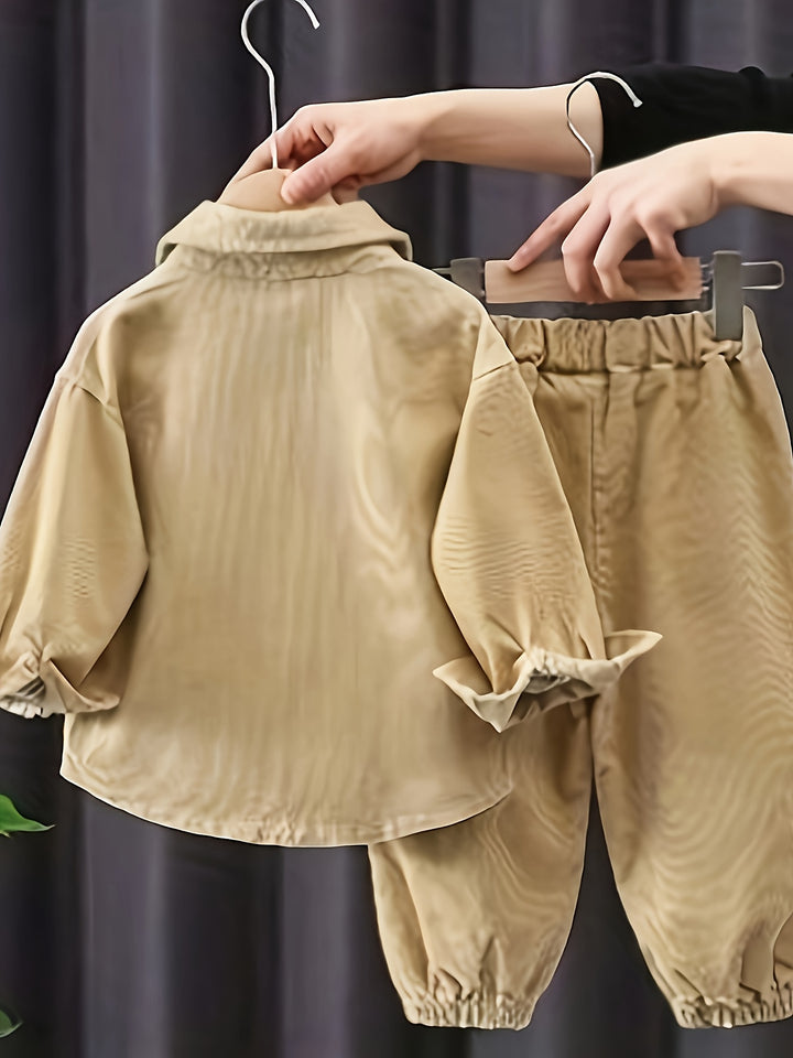 Children's beige outfit on a hanger against a dark background