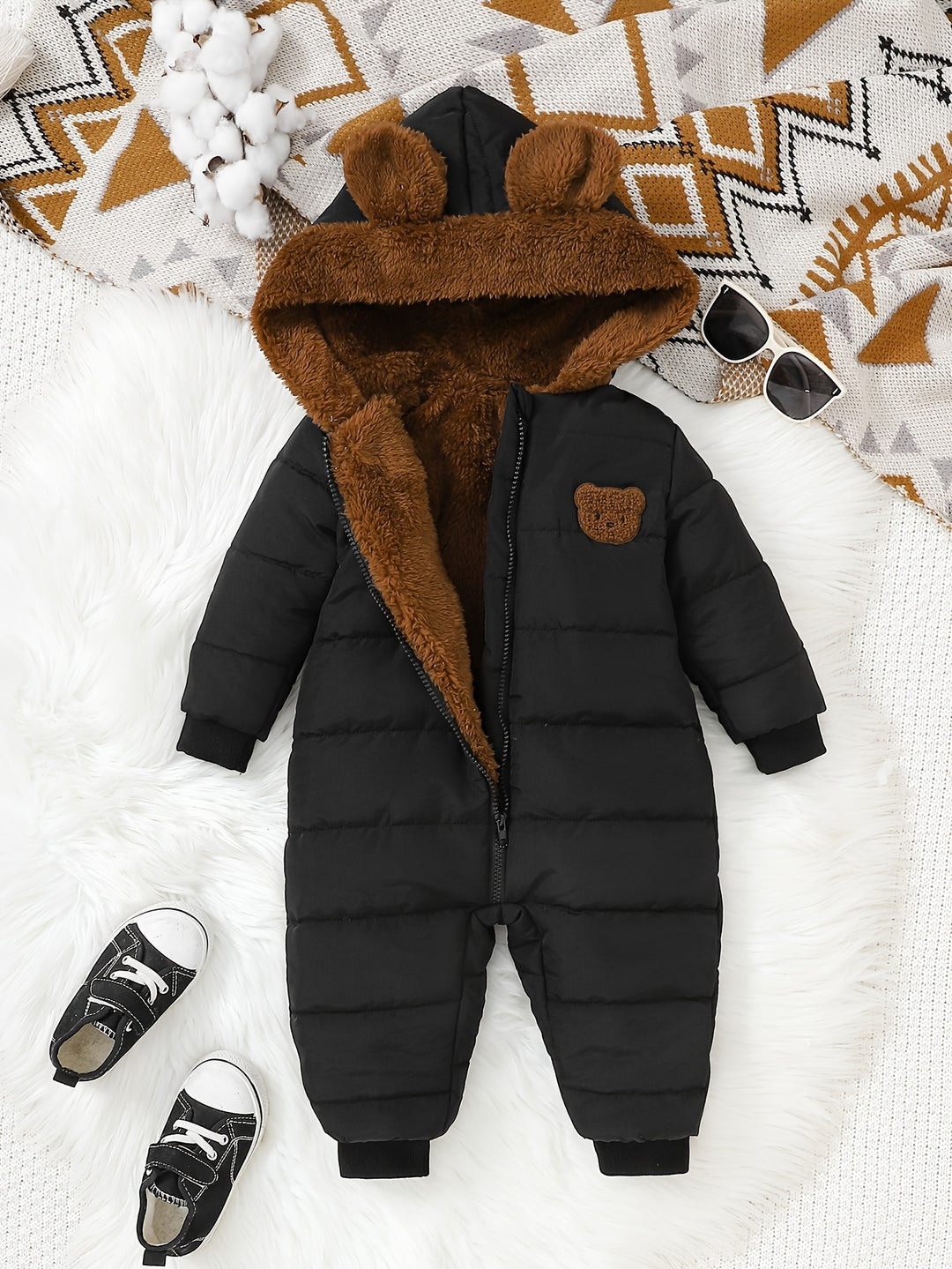 Black puffer snowsuit with brown fur hood on a patterned blanket