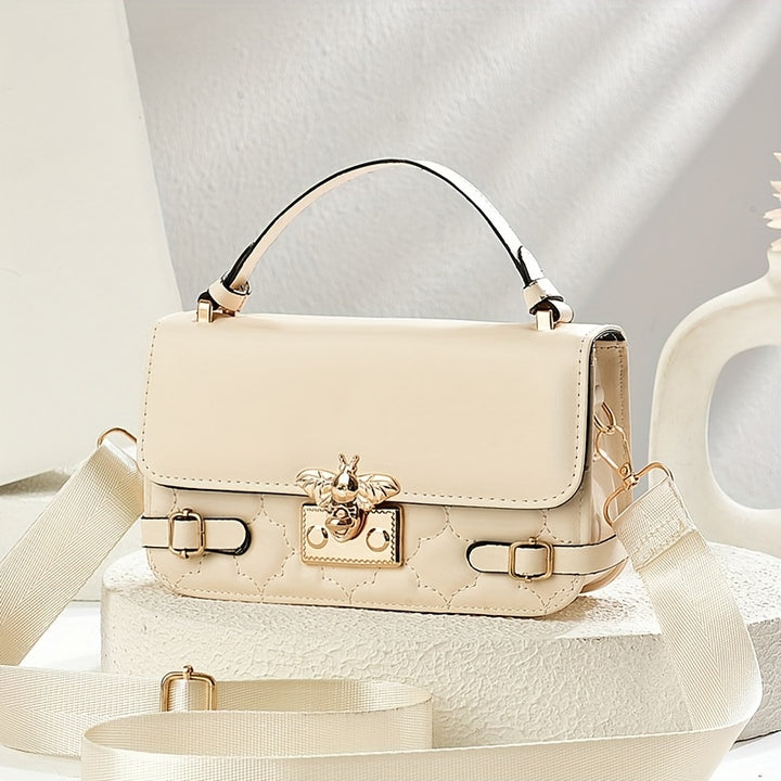 Beige handbag with gold accents on a light background