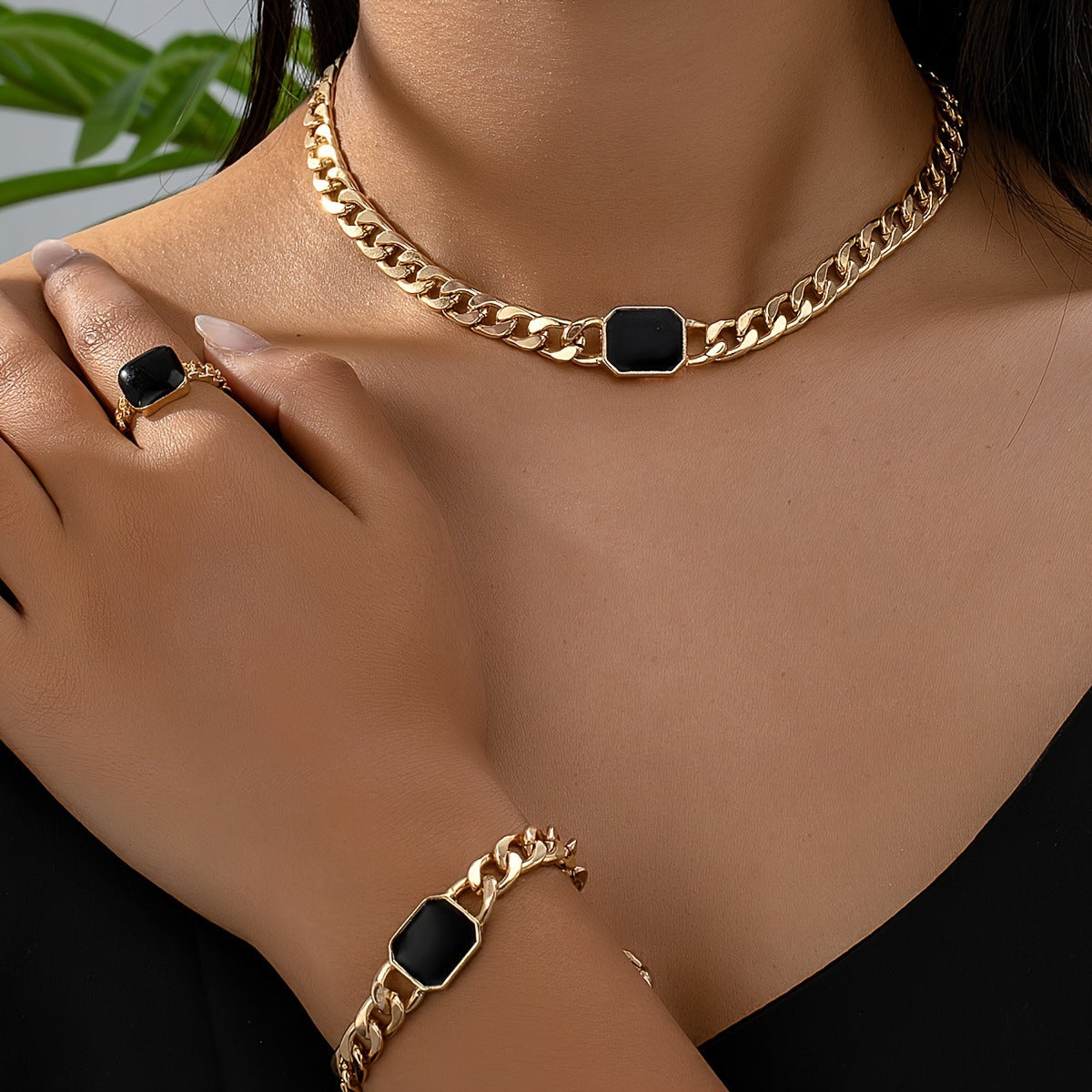 Gold-tone chain jewelry set with black octagon stone links: necklace, bracelet, and ring
