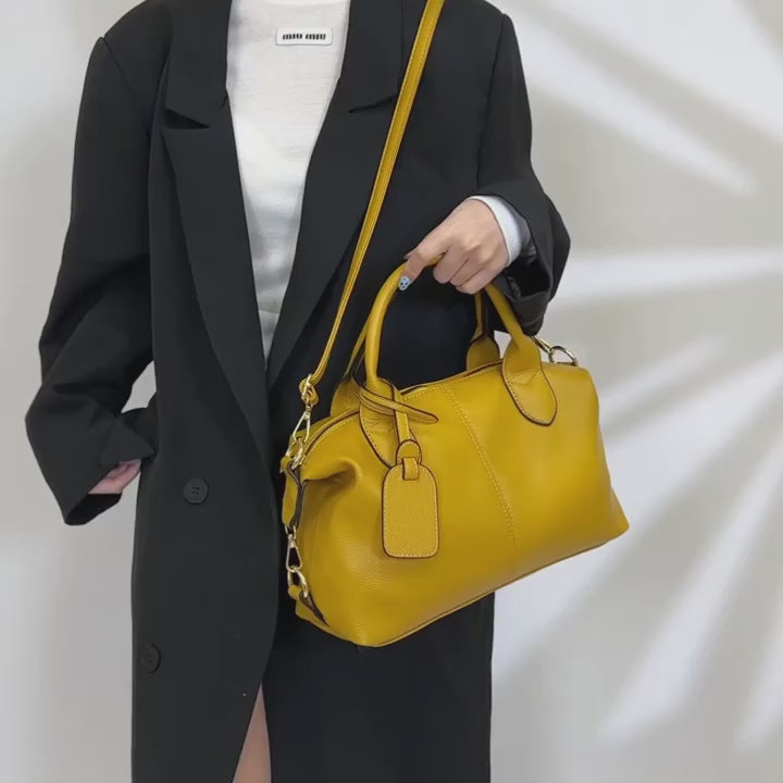 Video of Yellow handbag with a strap on a beige background
